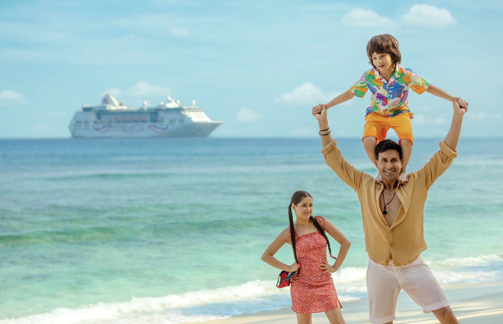 Cordelia Cruises #DestinationOfYourDreams campaign — family on tropical beach with cruise ship